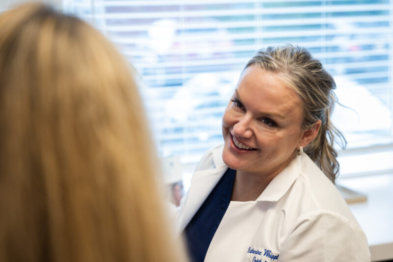 A specialist smiles while explaining treatment areas in a consultation. We keep our consultations light-hearted to discuss treatment options in a supportive environment.