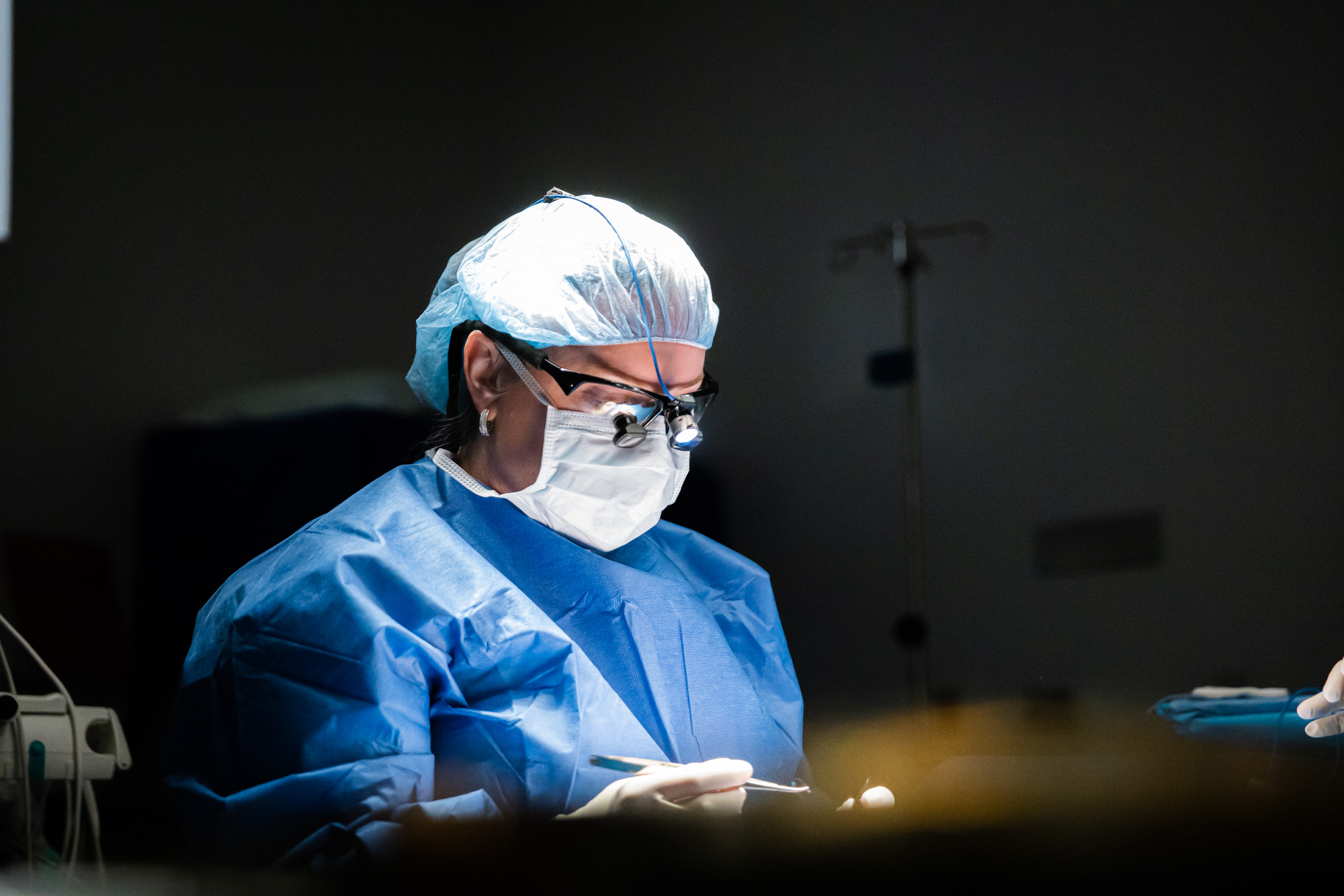 A surgeon focuses on a patient's facial plastic surgery.