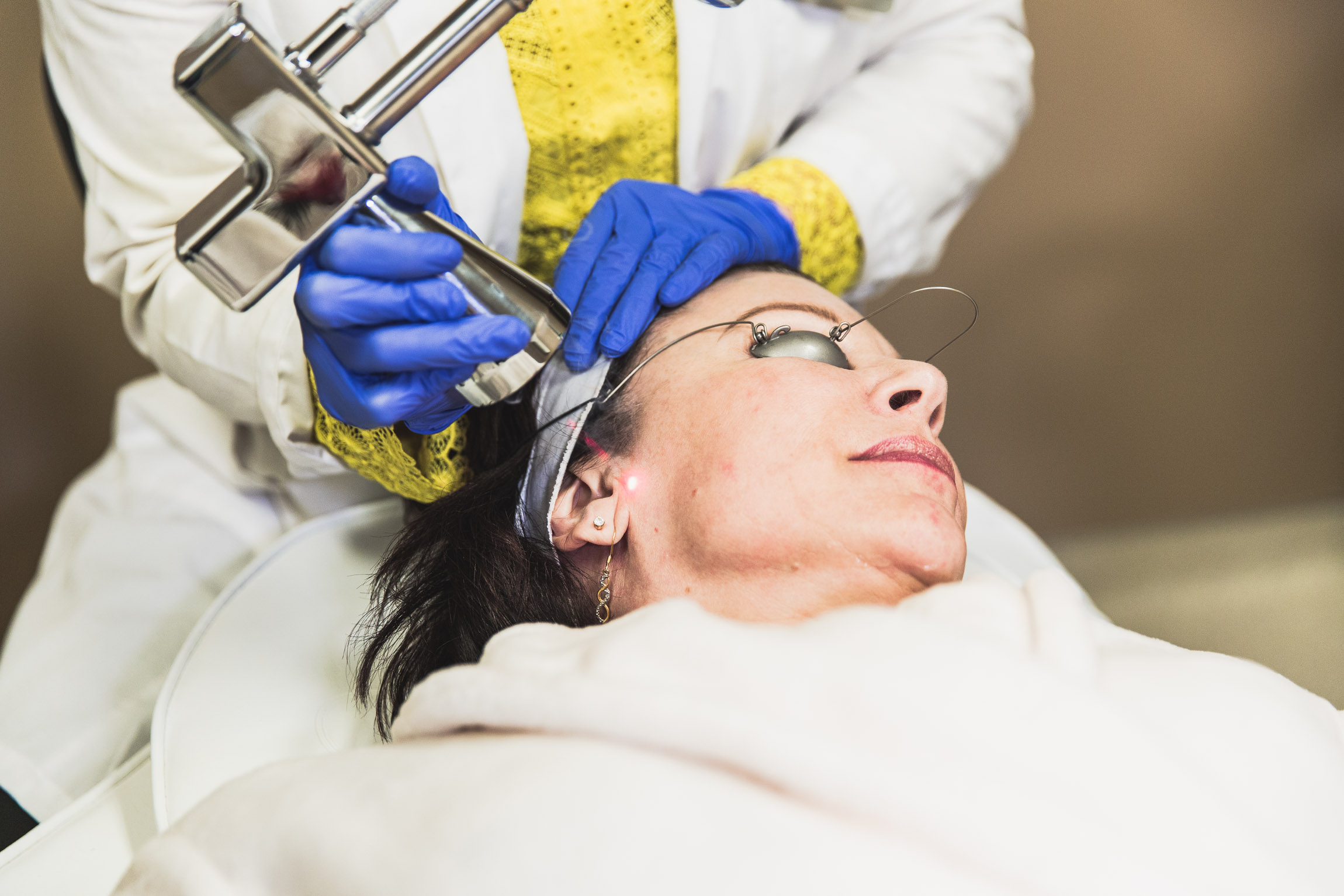 a laser specialist in Rochester performs facial on female patient