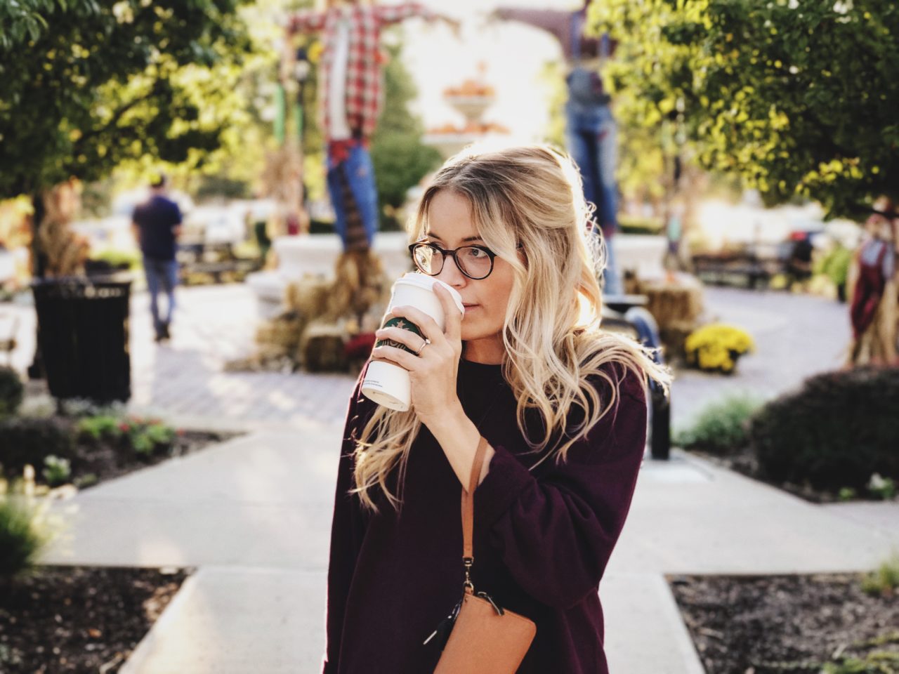 woman drinking coffee in a park after a photofacial in rochester, new york