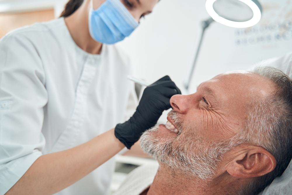 mature man smiling while getting an aesthetic procedure