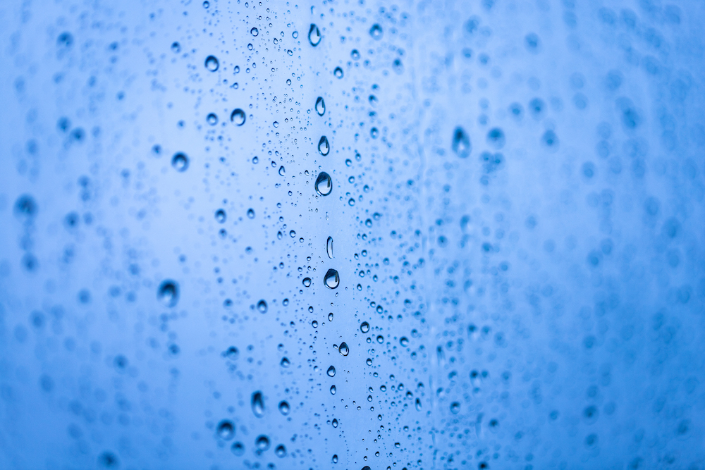 Raindrops on a window. Blue background.